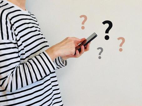 スマホの設定方法に悩む女性 スマホの設定方法に悩む女性 わからない,疑問,女性の写真素材