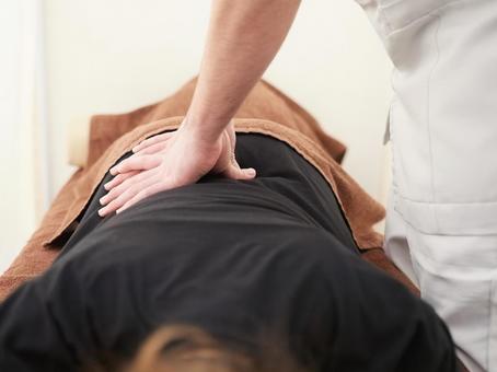 Japanese woman receiving a waist massage Japanese woman receiving a waist massage
