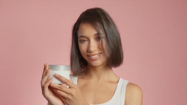 クリームジャーを持っている笑顔の女性 クリームジャーを持っている笑顔の女性 女性,外国人,アジア人の写真素材