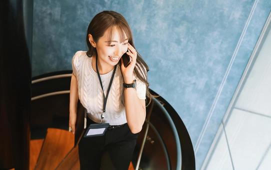 スマホで話しながら歩く笑顔の女性 スマホで話しながら歩く笑顔の女性 女性,スマホ,スマートフォンの写真素材