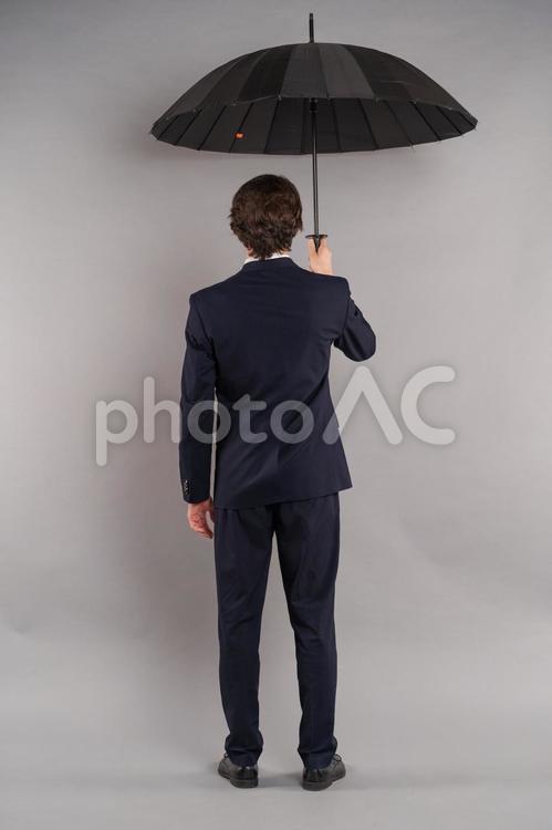 傘を差し立つ男性の後ろ姿 傘,黒,差すの写真素材