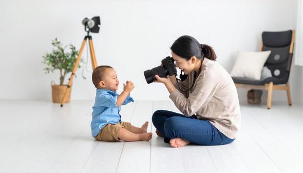 撮影対象の赤ちゃんに笑いかける笑顔の女性 撮影対象の赤ちゃんに笑いかける笑顔の女性の写真
