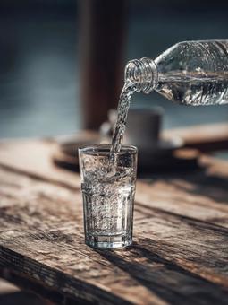 ペットボトルからコップへ水を注ぐ ペットボトルからコップへ水を注ぐの写真