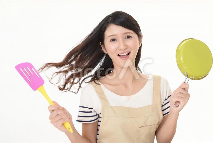 フライパンを持つ笑顔の主婦 女性,女,フライパンの写真素材