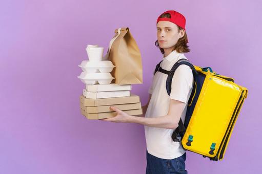 フードデリバリーの男性（紫背景） 配達,フードデリバリー,デリバリーの写真素材