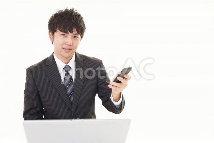 スマートフォンを持つビジネスマン 男性,ビジネスマン,男の写真素材