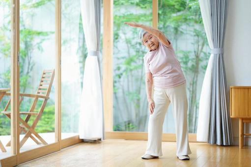 真剣な顔で体操するショートヘアの女性 女性,体操,伸ばすの写真素材