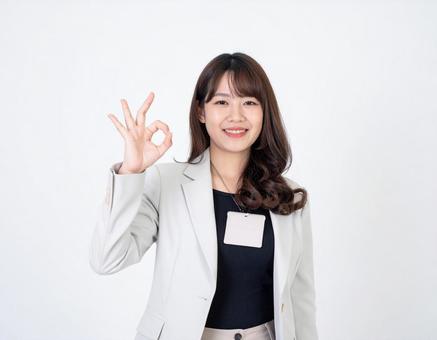 オーケーサインをするスーツ姿の女性の写真