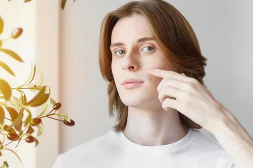 頬を指で触っているカメラ目線の男性 男性,外国人,欧米人の写真素材