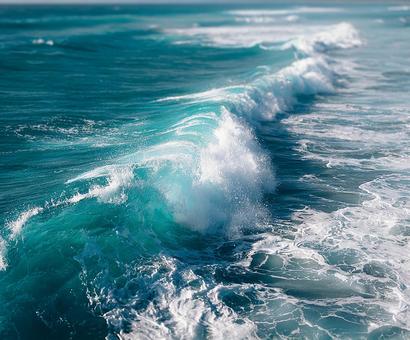 広がる青い海の波しぶき 広がる青い海の波しぶきの写真
