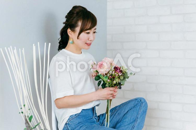 花束を持って椅子に座るアジア人女性 花,フローラル,椅子の写真素材