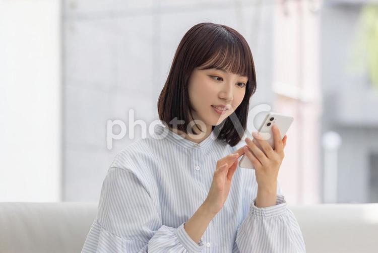 スマホを操作する若いビジネスウーマン 女性,ビジネス,スマホの写真素材