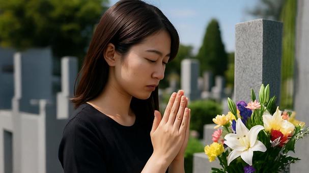 墓前祈る若い女性 墓前祈る若い女性の写真