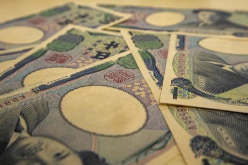 机の上に置かれた千円札の束の写真