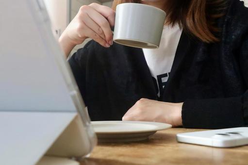 タブレットを見ながらコーヒーを飲む女性 タブレットを見ながらコーヒーを飲む女性 カフェ,女性,コーヒーの写真素材