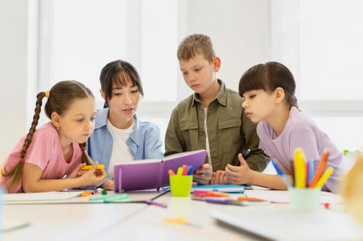 先生のノートを見る生徒たち 女性,女の子,男の子の写真素材