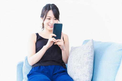 下着を着てスマホを使う若い女性 投稿,女性,スマートフォンの写真素材