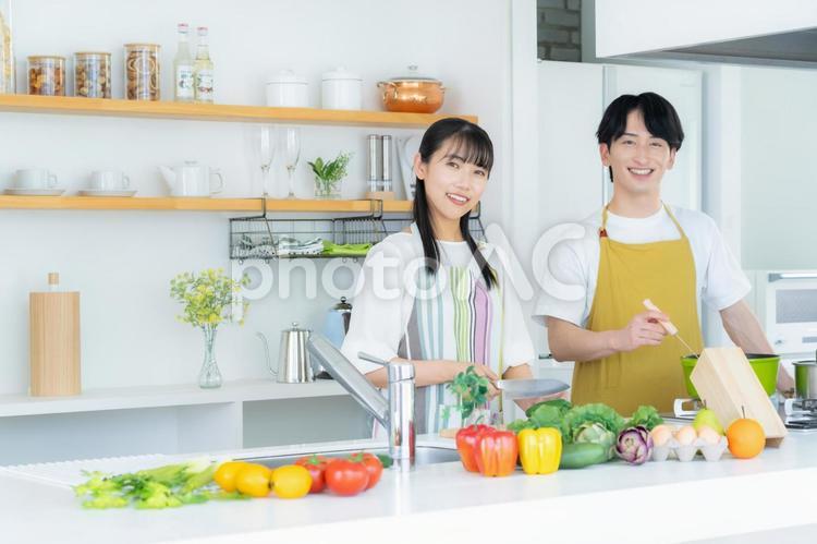 キッチンで料理を作る若い夫婦 夫婦,料理,キッチンの写真素材