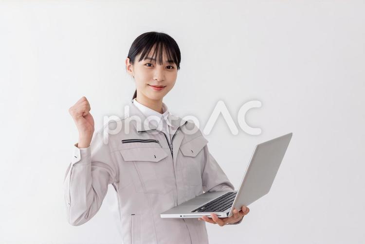 ノートパソコンを持つ作業服の女性 女性,人物,日本人の写真素材