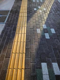 点字ブロックと射し込む光 点字ブロックと射し込む光の写真