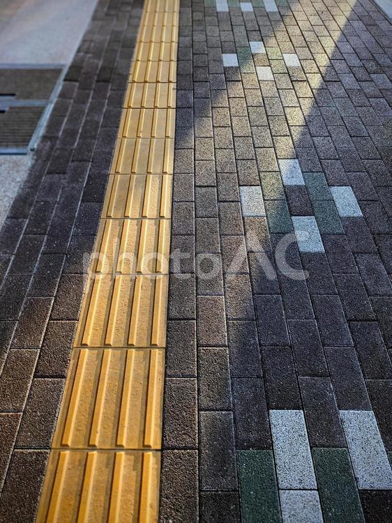 点字ブロックと射し込む光 点字ブロック,誘導ブロック,歩道の写真素材