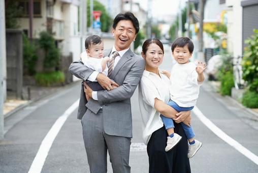 住宅街に立つ、笑顔の家族 住宅街に立つ、笑顔の家族 家族,育児,笑顔の写真素材