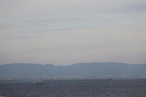 空と山並みと工場地帯と船と波の海の風景 空と山並みと工場地帯と船と波の海の風景 空,山並み,工場地帯の写真素材