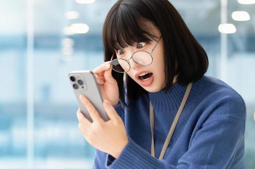 スマホの画面を見て驚くビジネスウーマン スマホの画面を見て驚くビジネスウーマン 女性,スマホ,スマートフォンの写真素材