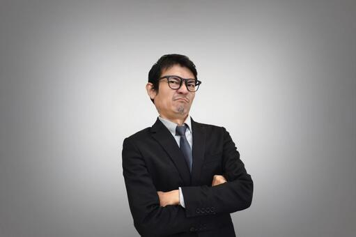 腕組みで不服そうな男性 不服,不満,怒りの写真素材