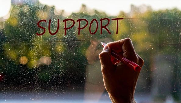 文字「Support」と赤ペンで書く手元 文字「Support」と赤ペンで書く手元の写真