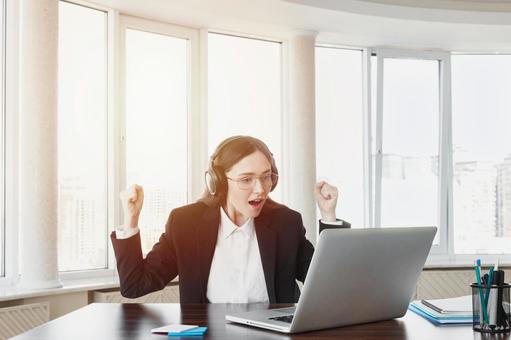 パソコンを見てガッツポーズで喜ぶ女性 女性,外国人,ガッツポーズの写真素材