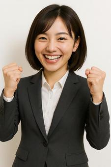 両手ガッツポーズで気合い十分のスーツ女性 両手ガッツポーズで気合い十分のスーツ女性の写真