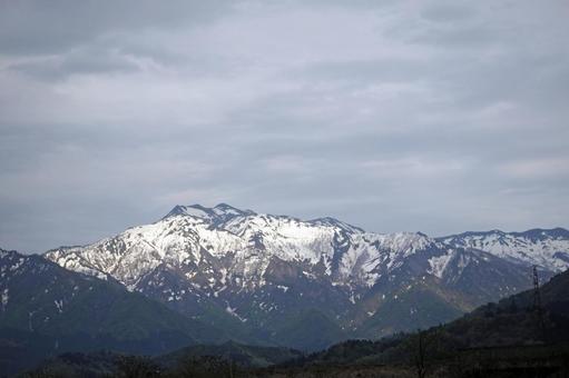 残雪の曇り空を行く春登山 残雪の曇り空を行く春登山 残雪,春登山,峠道の写真素材