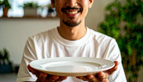 食後、空になったお皿を前に笑顔の男性 食後、空になったお皿を前に笑顔の男性の写真