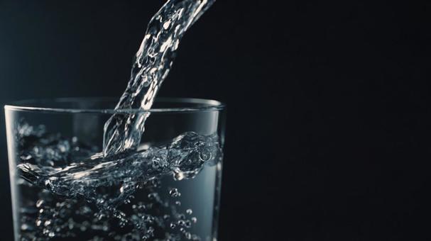 グラスに注がれる水の動きと飛沫の写真