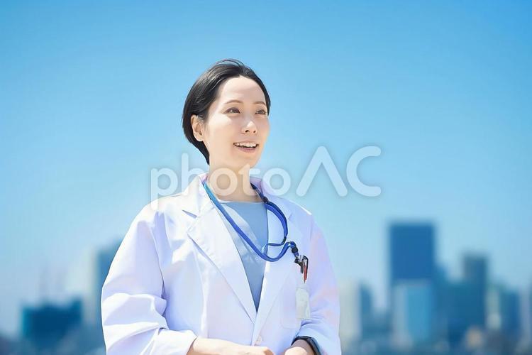白衣の女性と晴天の街並み 女性,医療,医者の写真素材
