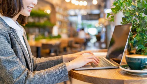 Hand of a woman using a computer at a cafe, JPG