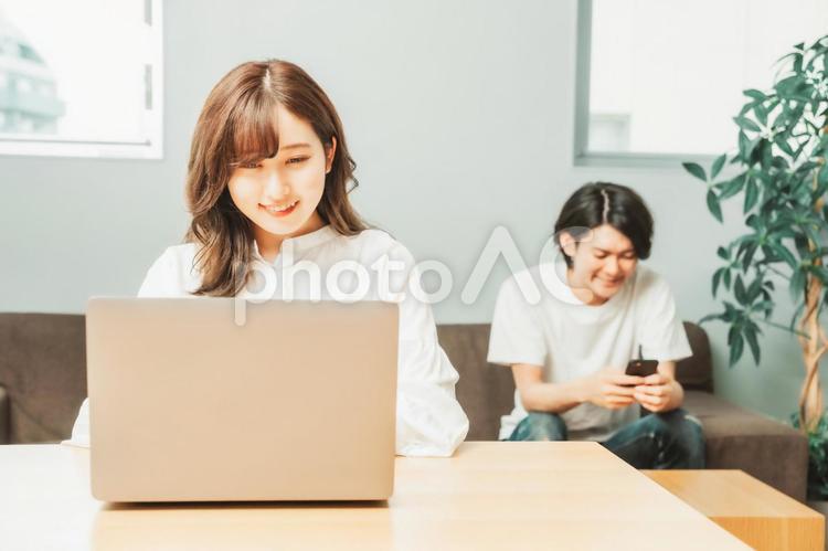 家でテレワークする男女（女性・笑顔） テレワーク,リモートワーク,ノートパソコンの写真素材