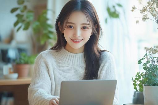 ノートパソコンを操作する若い女性 ノートパソコンを操作する若い女性の写真