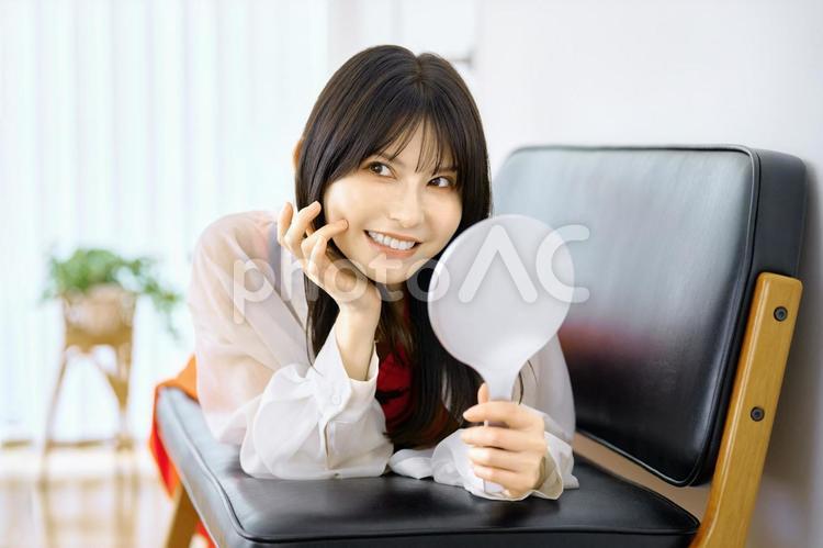 手鏡を持つ若い女性　ソファ 鏡,女性,ソファの写真素材