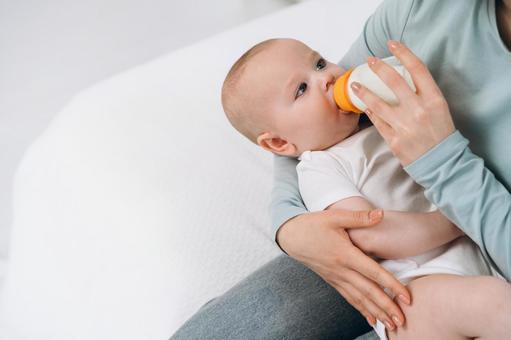 ミルクを飲みながら親を見る赤ちゃん ミルクを飲みながら親を見る赤ちゃん 赤ちゃん,哺乳瓶,飲むの写真素材