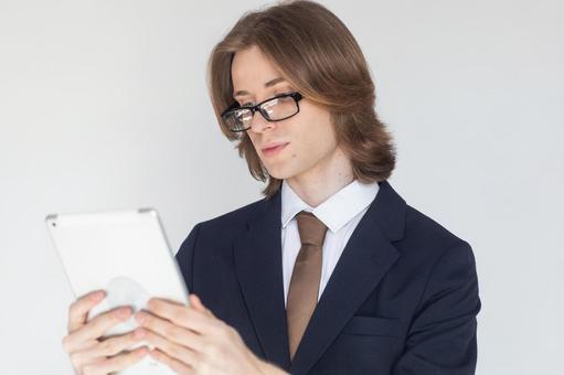 タブレットを使うスーツにメガネの男性 男性,外国人,欧米人の写真素材