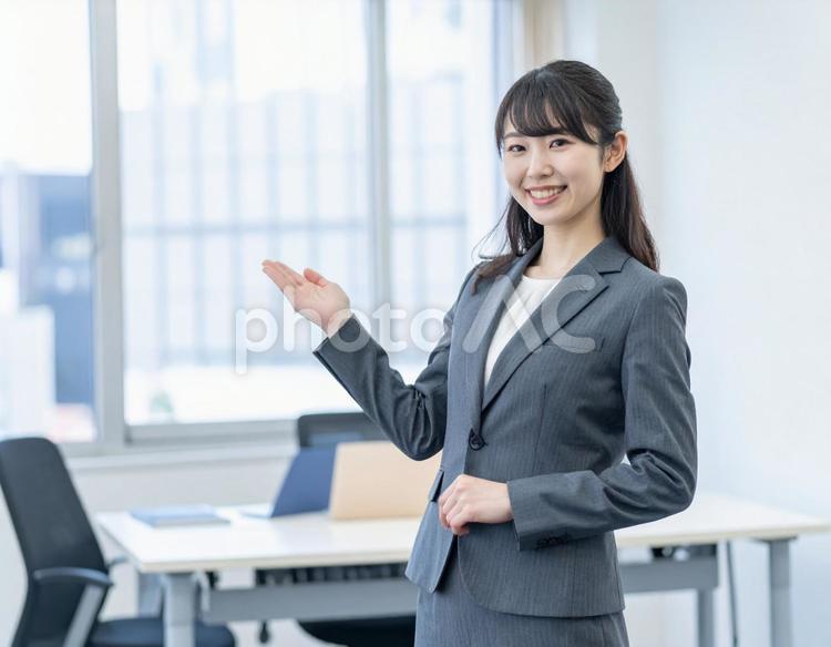 スーツ姿でオフィスを案内する女性 女性,スーツ,ビジネスの写真素材