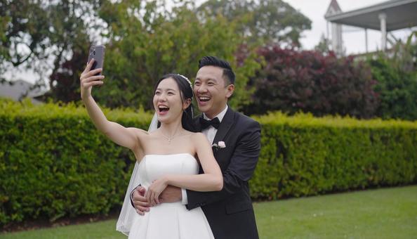 セルフィーを撮る新郎新婦 セルフィーを撮る新郎新婦の写真