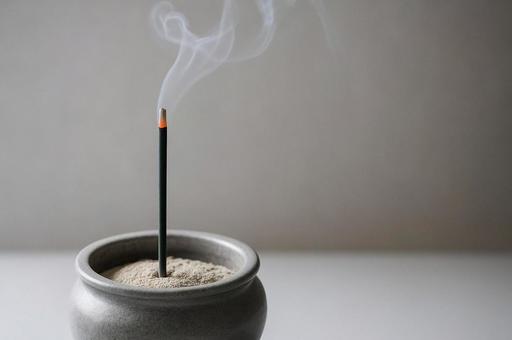 香炉に立つ線香と立ちのぼる煙・追悼・供養の写真