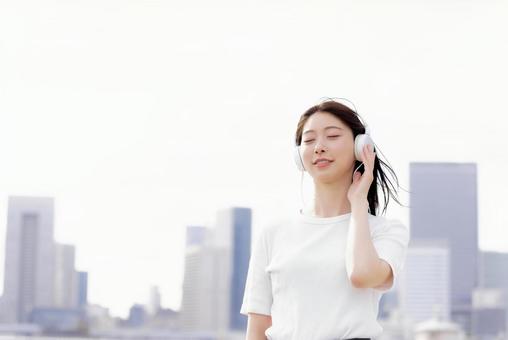 ヘッドフォンで音楽を聴く若い女性 ヘッドフォンで音楽を聴く若い女性 女性,ヘッドフォン,音楽の写真素材