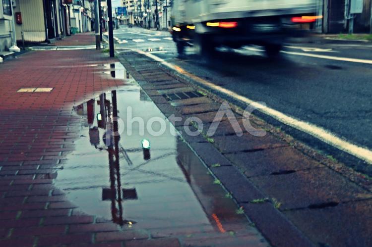歩道の水溜まりとトラックの光跡写真 夜景,車道,自動車道の写真素材