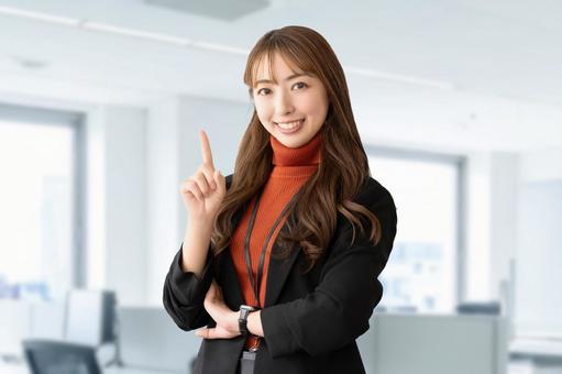 人差し指を立てて案内する笑顔の女性 女性,笑顔,指の写真素材