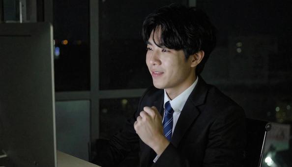 残業のオフィスで喜ぶビジネスマン 残業のオフィスで喜ぶビジネスマンの写真