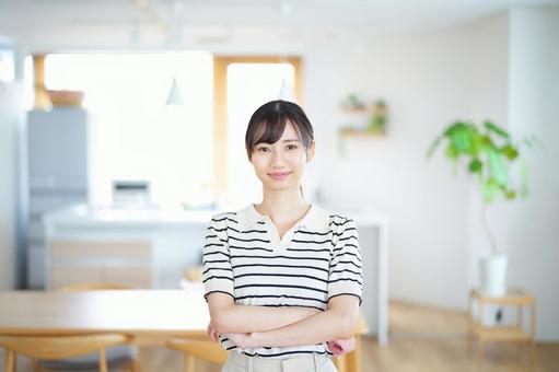 腕組みをして微笑む女性の写真